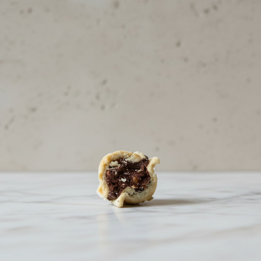 Handmade Romanian walnut-shaped cookies with buttery biscuit shells and chocolate walnut rum filling, sold in bags of 11 from North London bakery