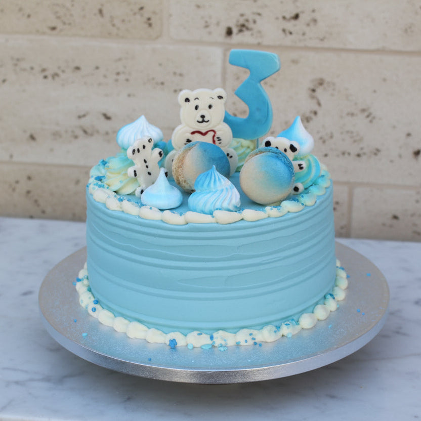 Custom baby celebration cake with pastel decorations, fondant baby toppers, and soft sponge layers, handmade in North London for showers or birthdays