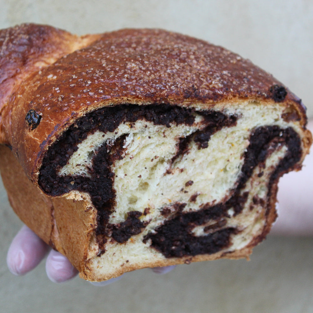 Traditional Romanian Cozonac sweet bread with a cocoa, orange zest and Turkish Delight filling, sliced to reveal its marbled interior