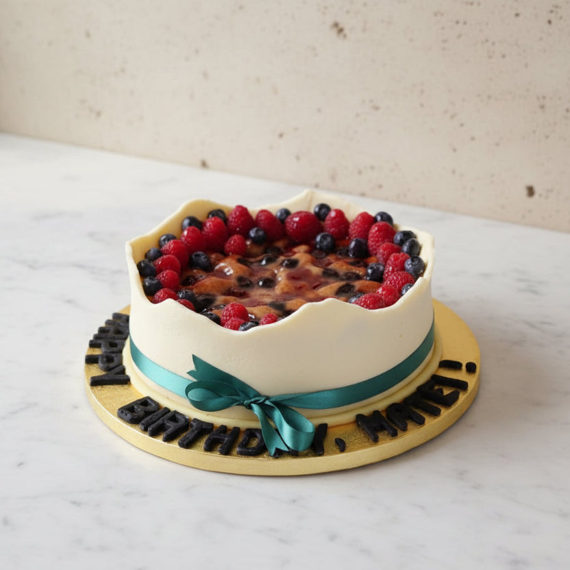 Vegan celebration cake topped with marzipan icing, filled with banana, raspberries and blueberries, decorated and handcrafted in North London